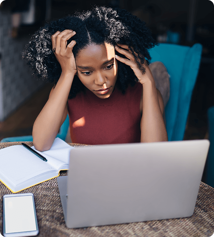 a photo of a sad woman looking at a laptop